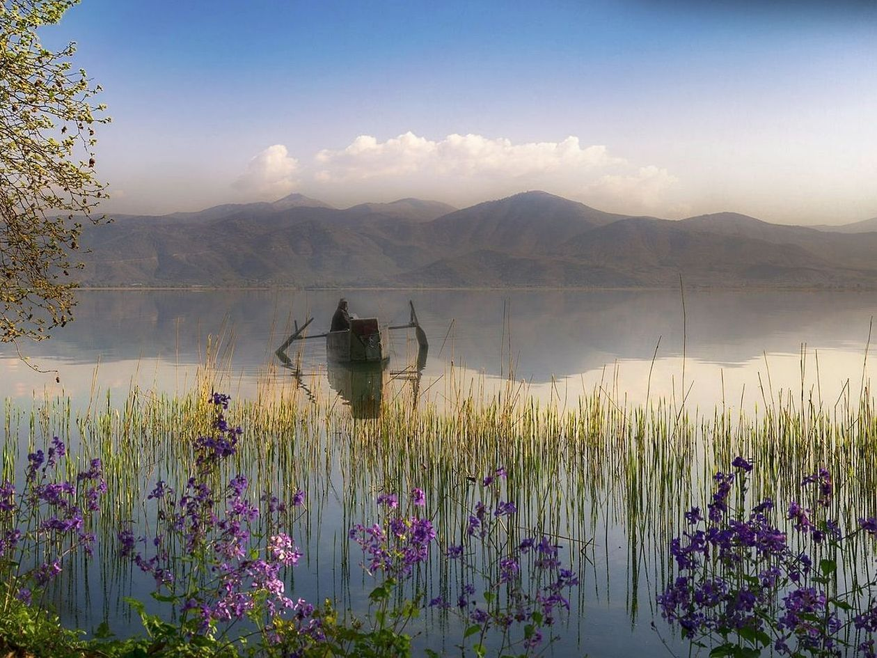 Una cresta lejana vista al amanecer sobre el lago de montaña